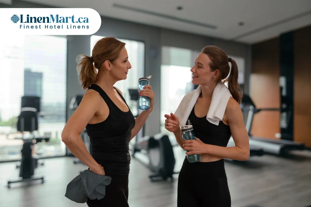 Commercial gym members using premium white, grey, brown, and green gym towels